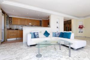 a living room with a white couch and a glass table at Rives dor4B in Juan-les-Pins