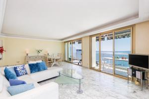 a living room with a white couch and a glass table at Rives dor4B in Juan-les-Pins