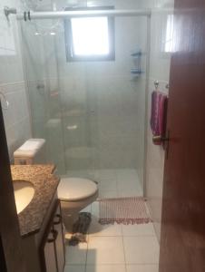 a bathroom with a shower and a toilet and a sink at Apartamento T-44 com Vista para o Mar 50 metros da Praia Mongaguá Piscina Wi-Fi in Mongaguá +16 photos