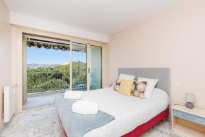 a bedroom with a large bed and a large window at Rives dor4B in Juan-les-Pins