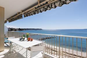 a white table and chairs on a balcony with the ocean at Rives dor4B in Juan-les-Pins