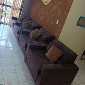 a row of brown couches in a living room at Apartamento T-44 com Vista para o Mar 50 metros da Praia Mongaguá Piscina Wi-Fi in Mongaguá