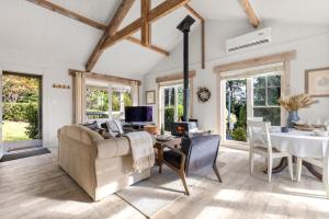 a living room with a couch and a table at Mulgrave House & Cottage in Bellawongarah