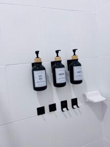 four bottles of soap hanging on a wall in a bathroom at Loft Mango in Tuxtla Gutiérrez