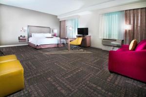 a hotel room with a bed and a desk and chairs at Hampton Inn & Suites La Porte, TX in La Porte