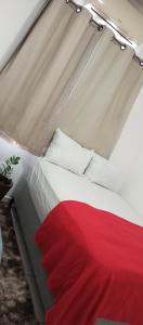 a bed with red and white sheets and pillows at Bozena Beach Stay in Itacaré +2 photos