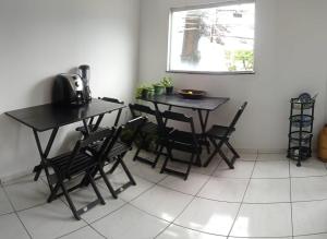 a dining room with two tables and chairs and a window at Bozena Beach Stay in Itacaré