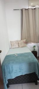 a bedroom with a bed with a blue blanket on it at Bozena Beach Stay in Itacaré