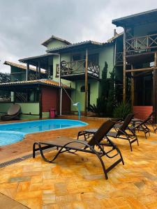 a group of chairs sitting in front of a house at Pousada Lapralapa in Santana do Riacho