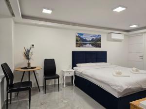 a bedroom with a bed and two chairs and a table at Jacuzzi & Sauna Edy room - city center in Zagreb