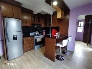 a kitchen with a refrigerator and a table and chairs at Hospedaje 'Los Ángeles ' in Huasca de Ocampo