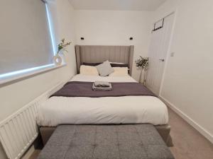 a bedroom with a large bed with a large window at Gatwick Cozy Stopover 4 bedroom house with free Parking in Copthorne