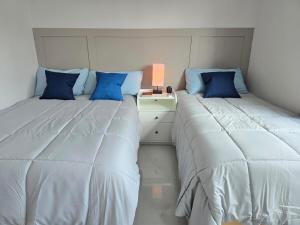 two beds sitting next to each other in a bedroom at Casa amplia para grupos Remodelada y centrica in Guadalajara