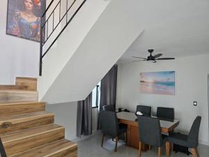 a dining room with a table and chairs and a staircase at Casa amplia para grupos Remodelada y centrica in Guadalajara
