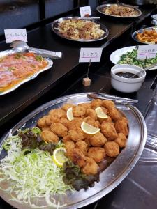 a plate of food on a table with plates of food at Hotel Crown Hills Kumamoto in Kumamoto