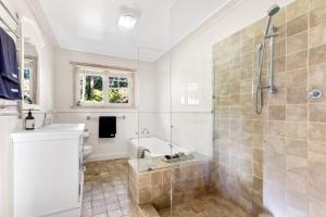 a bathroom with a shower and a tub and a sink at Mulgrave House in Bellawongarah +22 photos