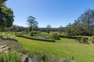 a garden with a pond and a grass field at Mulgrave House in Bellawongarah