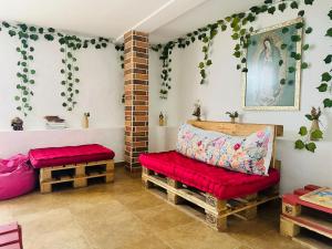 a living room with a red bench and ivy at Aloja-T Hostal Jericó in Jericó