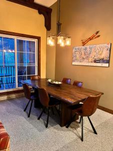 a dining room table with chairs and a large window at Manoir Signature in Mont-Tremblant