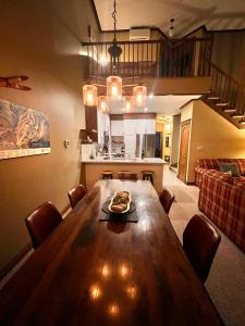 a living room with a wooden table and a kitchen at Manoir Signature in Mont-Tremblant