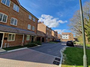 an empty street in front of a brick building at Gatwick Cozy Stopover 4 bedroom house with free Parking in Copthorne