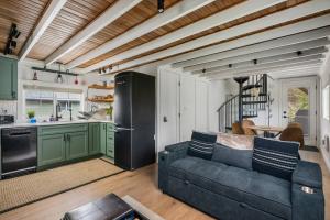 a living room with a blue couch and a kitchen at Cozy Coastal Cabin in Rockaway Beach