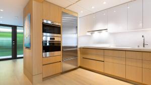 a kitchen with wooden cabinets and stainless steel appliances at ❤PiH❤ Hapuna Surfside Beachfront Steps From Ocean B26 in Hapuna Beach