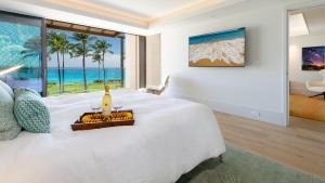 a bedroom with a large white bed with a view of the ocean at ❤PiH❤ Hapuna Surfside Beachfront Steps From Ocean B26 in Hapuna Beach +39 photos