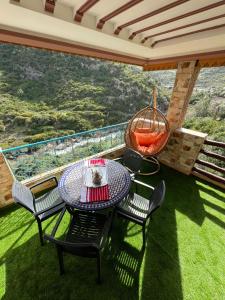 a patio with a table and chairs and a swing at Hotel nabil in Akchour