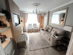 a living room with a couch and a window at Carrick's Cosy Haven in Carrickfergus