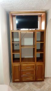 a entertainment center with a flat screen tv on top at Gardenias Suites Lite in Ibarra