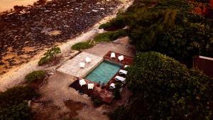 an overhead view of a swimming pool with white lounge chairs at FAKARAVA - Teariki Lodge 1 in Fakarava
