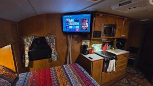 a small room with a bed and a tv in a room at Edith the Happy Camper in High Springs