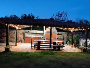 a picnic bench under a pergola with lights at Cabaña Barichara in Barichara