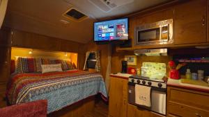 a bedroom with a bed and a television in a train at Edith the Happy Camper in High Springs