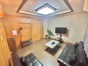a living room with a couch and a television at HoTTOSTAY矢田 in Nagoya