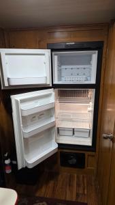 an empty refrigerator with its doors open in a room at Edith the Happy Camper in High Springs