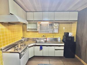 a small kitchen with a sink and a stove at HoTTOSTAY矢田 in Nagoya