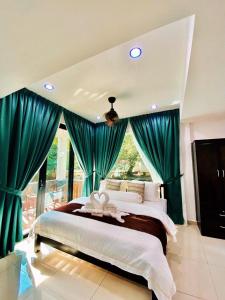 a bedroom with a large bed with blue curtains at Bidaisari Resort in Kampong Sum Sum +15 photos