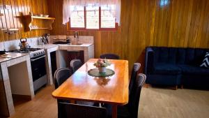 a kitchen with a wooden table with a vase of flowers on it at Böttger Haus in Oxapampa