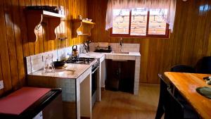 a kitchen with wooden walls and a stove top oven at Böttger Haus in Oxapampa +2 photos