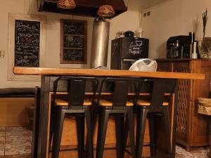 a bar with black stools at a counter in a kitchen at Hostal Boutique El Vergel Azul in Castro