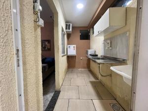 a hallway of a room with a sink and a kitchen at Recanto Carioca Aconchegante in Rio de Janeiro