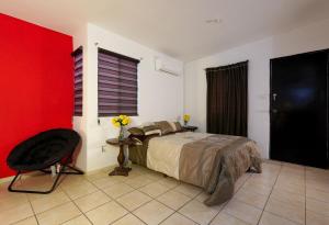 a bedroom with a bed and a red wall at Ribera Dorada in Monterrey