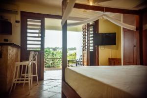 a bedroom with a bed and a view of a balcony at Fatumaru Lodge in Port Vila