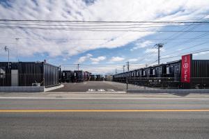 an empty street with a train on the road at HOTEL R9 The Yard Minamiarupusu in Shimo-iino