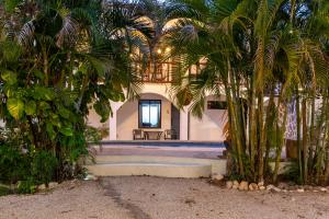 a house with palm trees in front of a building at Nosara Hotel Playa Garza in Garza