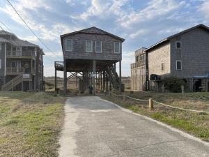 a house on a wooden structure next to a road at 57151 Lighthouse Rd Home in Hatteras