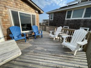 three chairs and a table on a deck at 57151 Lighthouse Rd Home in Hatteras