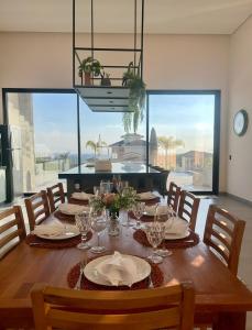 a dining room with a wooden table with glasses on it at Cantinho Solis in Itupeva